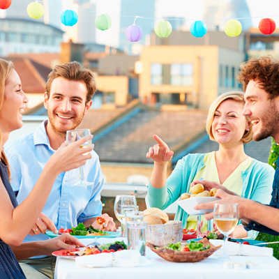Grupo de 4 jóvenes comiendo en una terraza